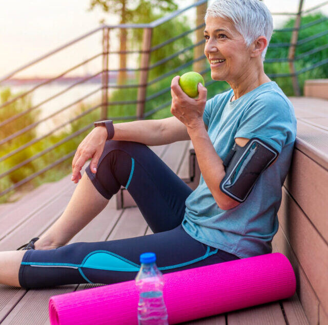 Active,Senior,Woman,Eating,Apple,After,Exercise.,Mature,Woman,Holding