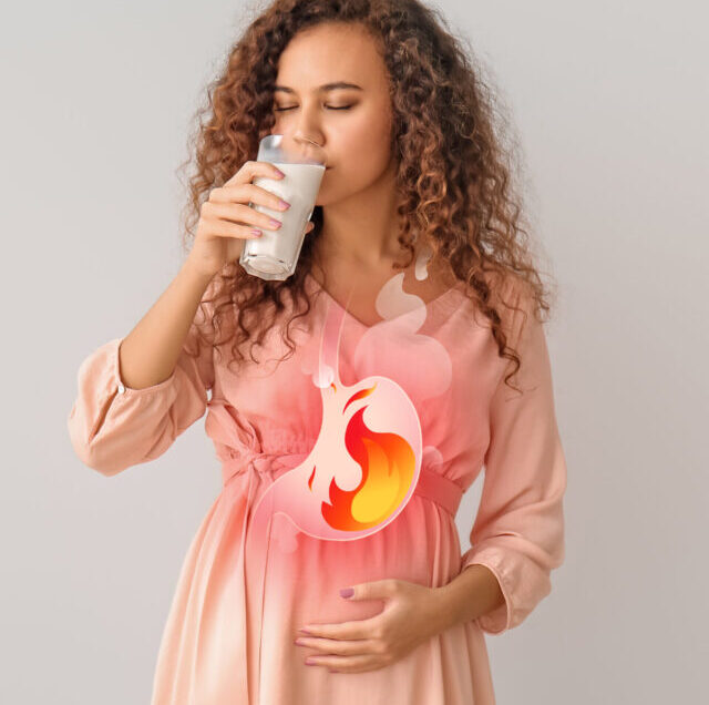 Pregnant,African-american,Woman,Drinking,Milk,To,Relieve,Heartburn,On,Grey