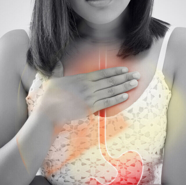 Woman,Suffering,From,Acid,Reflux,Or,Heartburn,Against,Gray,Background